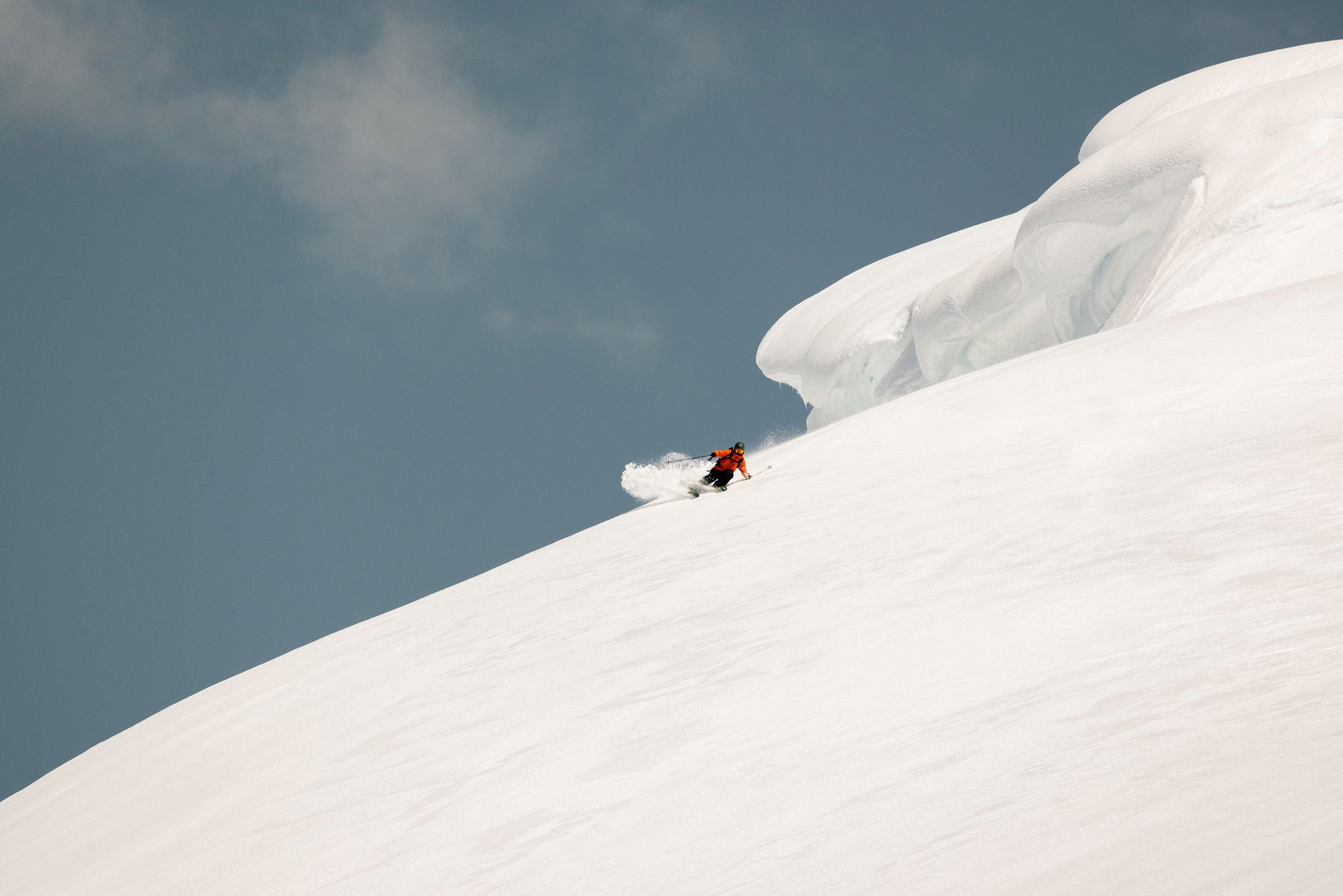 person in the distance skiing show deep snow with clear blue sky
