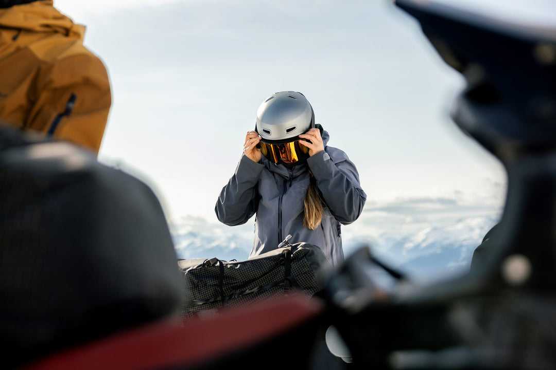 person putting on ski goggles over their snow helmet
