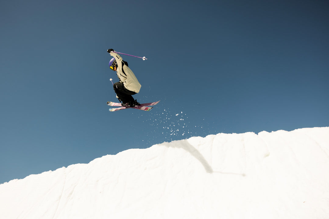 Skier performing a jump against a clear blue sky
