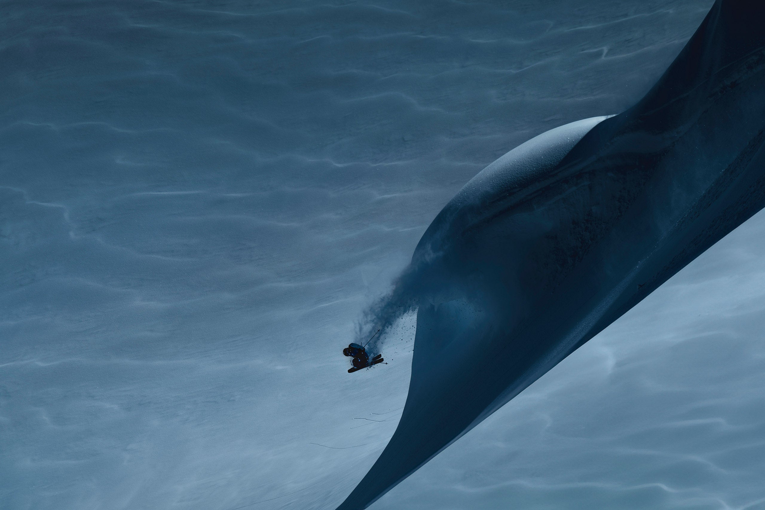 skier in air after a jump in a dark moody and snowy landscape