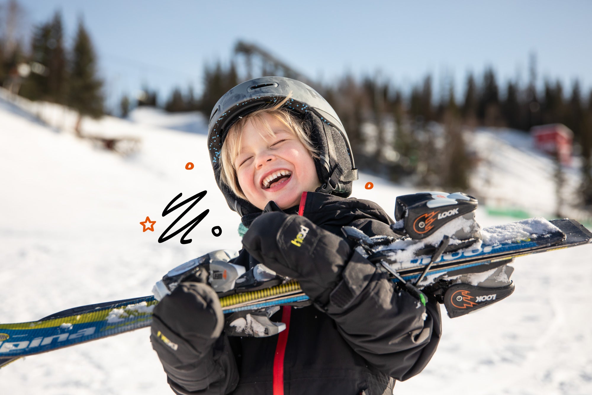 Child with skis and helmet on a snowy slope